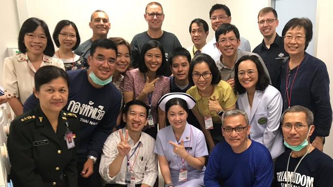 Dr Richard Harris (centre, back) and his dive partner, Craig Challen (left, back), with medical staff caring for the rescued children in Chang Rai hospital. (Pic: DFAT)