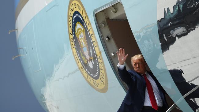 US President Donald Trump waves as he boards Air Force One prior to departure from Miami International Airport in Miami overnight.