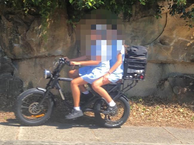 Secondary schools students, without helmets on an e-bike on Oliver St, Freshwater. Picture: Jim O'Rourke