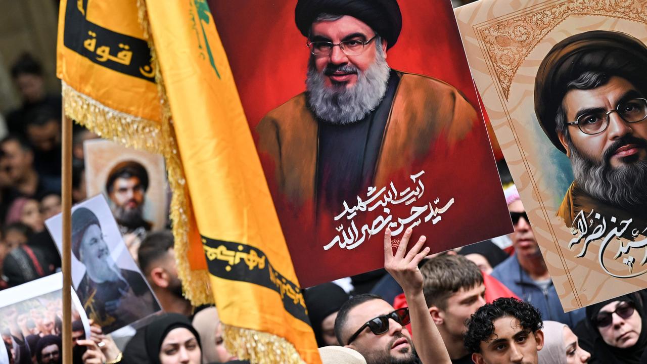 Demonstrators hold flags and pictures of Hassan Nasrallah, late leader of the Lebanese group Hezbollah, at a protest rally in Sydney’s CBD. Picture: Saeed Khan/AFP