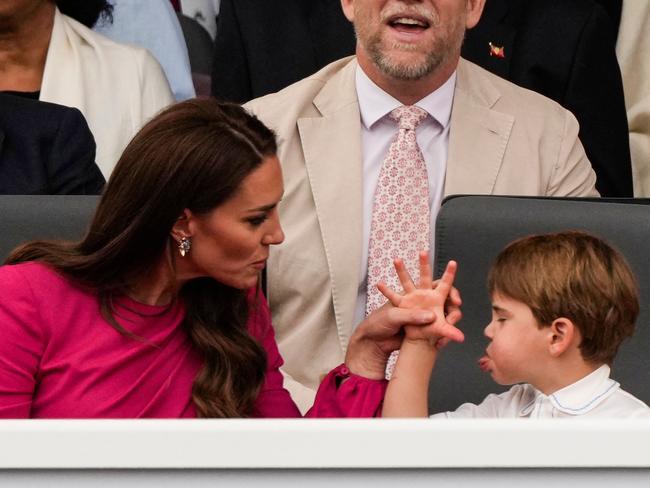 The Duchess of Cambridge reasons with her son Prince Louis after he pokes his tongue out at the Jubilee Pageant. Picture: AFP