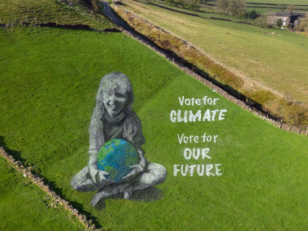 An anamorphic field painting of a girl holding the Earth, created by ‘Sand In Your Eye’ for Earth Day, covers a hillside above Hebden Bridge, England. Crafted over three days using line marker paint, the artwork urges voters to prioritise climate issues in upcoming UK elections. Picture: Oli Scarff/AFP