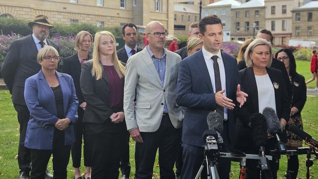 New Labor leader Dean Winter is flanked by party MPs as he speaks to the media on Parliament Lawns in Hobart on Wednesday.