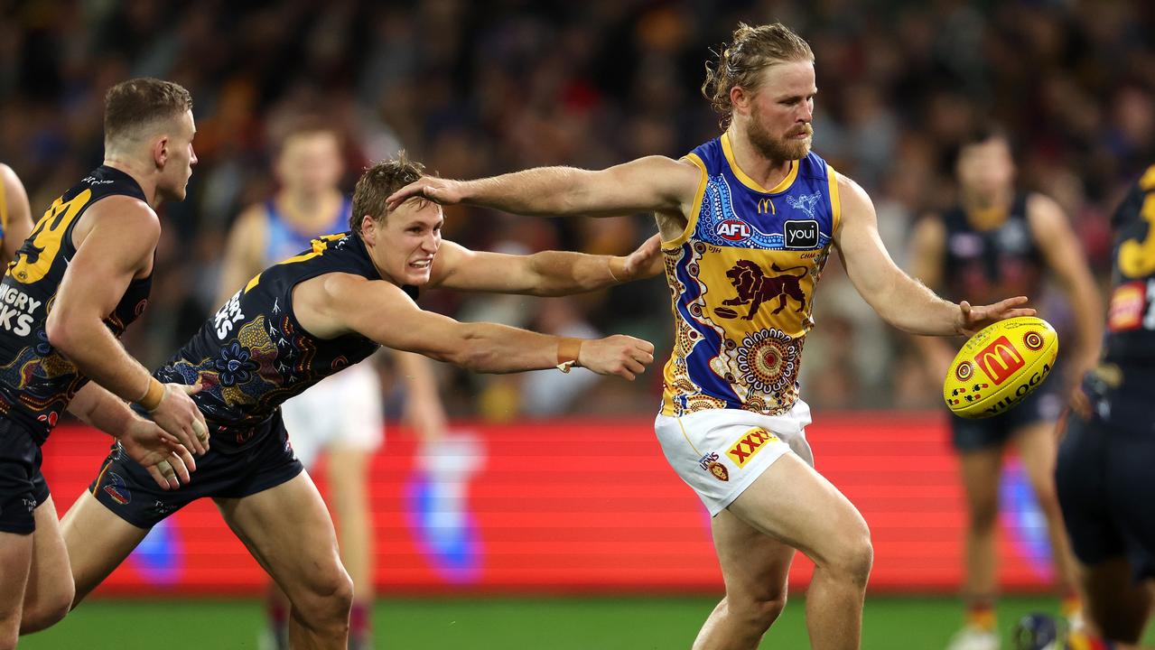 Daniel Rich of the Lions kicks the ball from Jordan Dawson of the Crows during the 2023 AFL Round 11 match between the Adelaide Crows and the Brisbane Lions at Adelaide Oval on May 28, 2023 in Adelaide. Picture: Sarah Reed/AFL Photos via Getty Images.