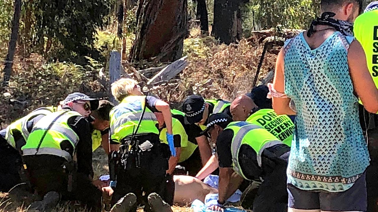 Emergency services attend to a man before he is loaded into an ambulance. 