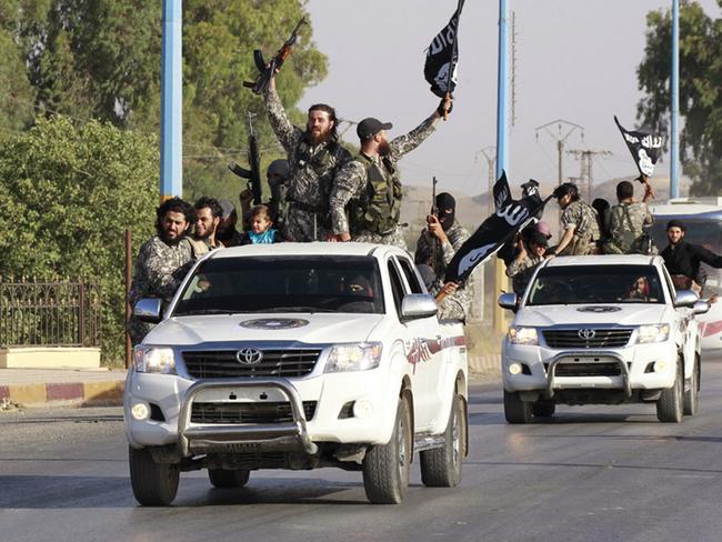 Militant Islamist fighters wave flags as they take part in a military parade along the streets of Syria's northern Raqqa province / Picture: Reuters