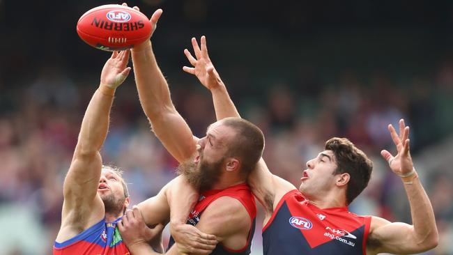 Christian Petracca of the Demons goes third man up as Stefan Martin of the Lions and Max Gawn of the Demons compete in the ruck. This will be illegal in 2017.