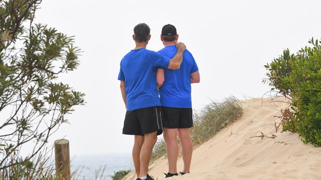 Paul Grimmer consoles bother Ricki Nash at Fairy Meadow beach before the unveiling. Picture: Simon Bullard