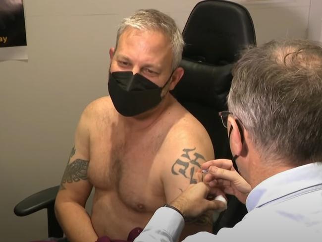 Dr Sutton took off his shirt off to receive a vaccination, revealing his tatts. Picture: Supplied