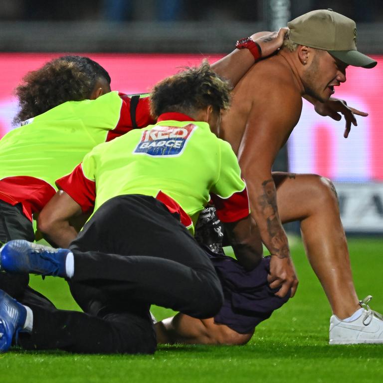 One of the pitch invaders is caught by security.