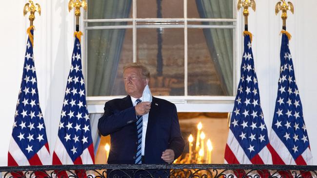 President Donald Trump removes his mask upon return to the White House from Walter Reed National Military Medical Center where he spent three days hospitalised for coronavirus. Picture: Win McNamee/Getty Images