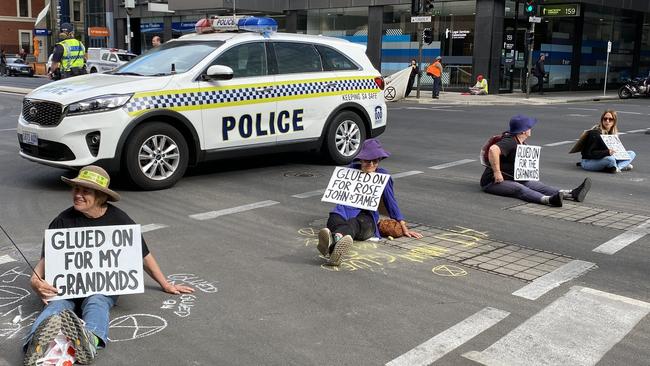 The protesters glued themselves to the road outside the Santos building, forcing police to block off the street and causing significant traffic delays across the city. Picture: Patrick James