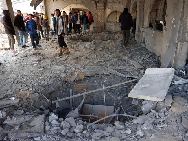 Palestinians check a crater caused by an Israeli strike that hit an administrative building in Khan Yunis in the southern Gaza Strip on Thursday. Picture: AFP