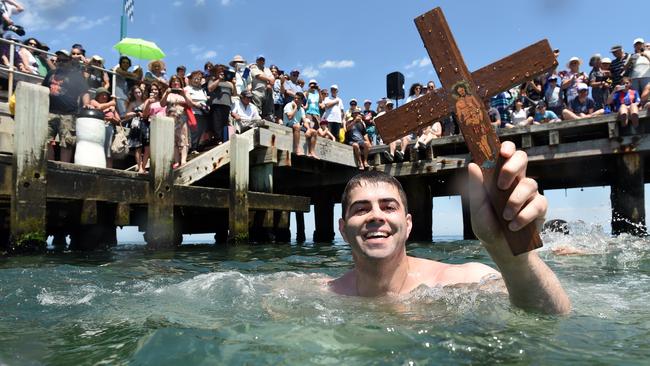 Theo Demetriou, 28, from Clayton was the first among a group of swimmers to retrieve the cross thrown into the waters off Frankston Pier. Picture: Jason Sammon