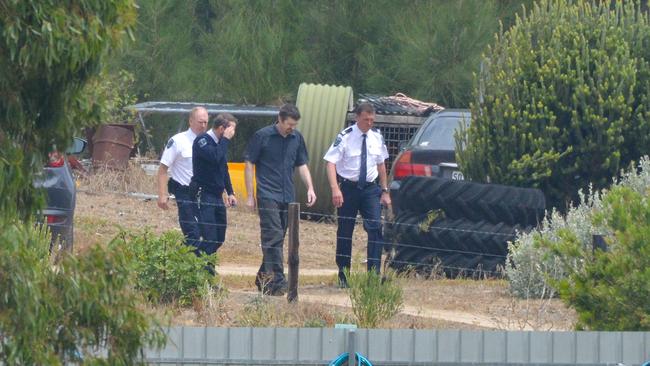 Accused Gene Bristow, in blue short sleeved shirt, with sheriff’s officers on his property in Meningie. Picture: Brenton Edwards