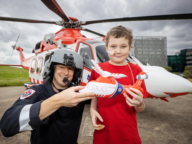 Isaac Watson, 9, with Air Crew Officer Daniel Antwis, and the air ambulance. Picture: Mark Stewart