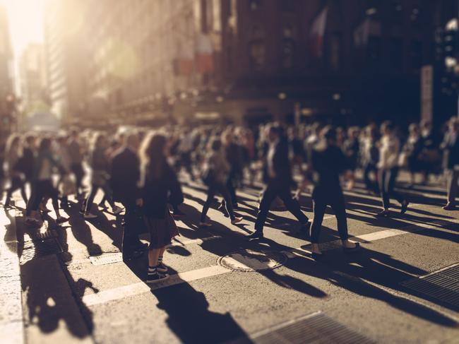 Crowd of people walking over the crosswalk at sunset. Sydney, Australia