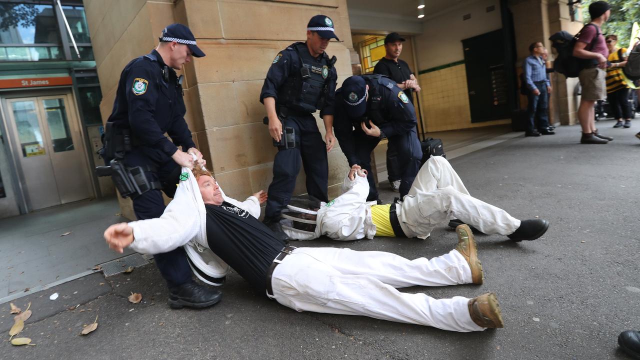 Police drag away protesters who laid down in the middle of traffic in Sydney on Tuesday. Picture: Richard Dobson