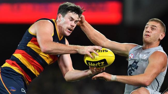 Mitch McGovern takes a grab in front of Carlton’s Liam Jones. Picture: AAP Image/David Mariuz