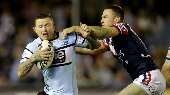 Shark's Todd Carney attempts to bust the tackle of Rooster's James Maloney. Picture Gregg Porteous