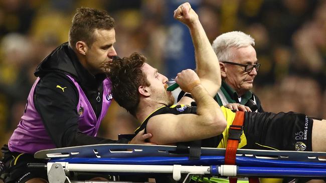 Reece Conca salutes the crowd as he is stretchered off.