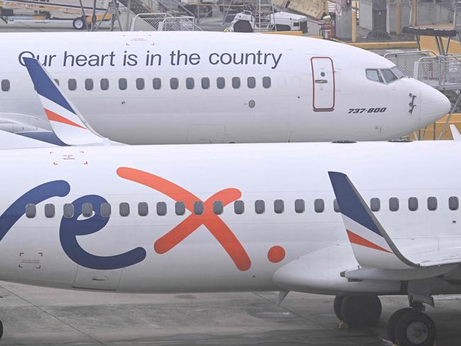 Rex Airlines Boeing 737 planes lay idle on the tarmac at Melbourne's Tullamarine Airport on July 31, 2024. The Australian regional airline Rex cancelled flights as it entered voluntary administration on July 31, leaving the fate of the country's third-largest carrier in serious doubt. (Photo by William WEST / AFP)