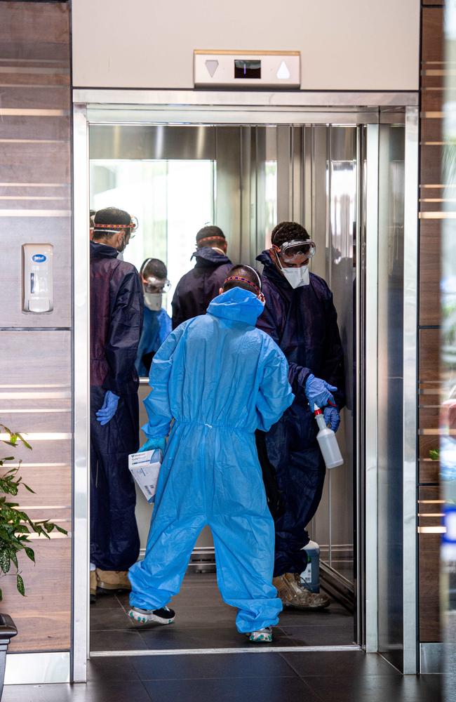 Cleaners enter a premises in Darwin to sanitise a workplace where a close contact of someone who has contracted coronavirus is employed. Picture: Che Chorley