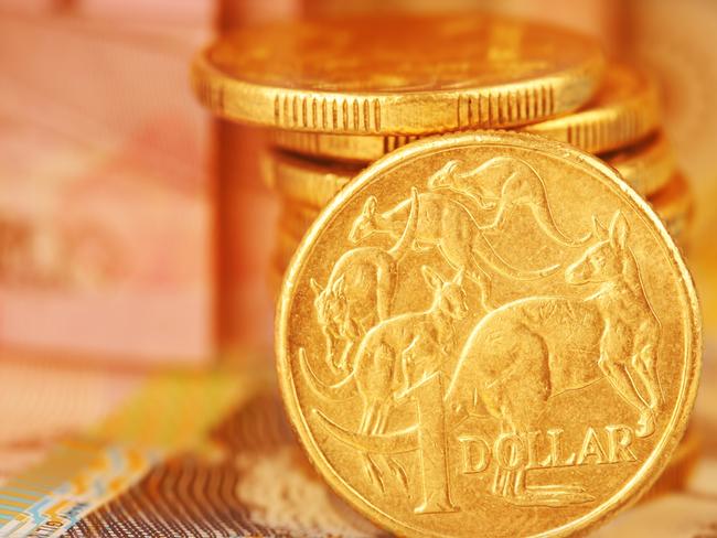 Australian Dollar Coin.  Note this is a circulated coin so has some nicks and scratches.  Stock image of a pile of Australian dollars with Australian money in background generic