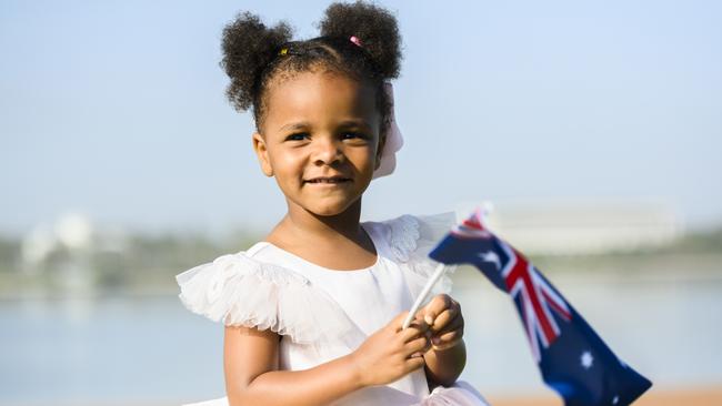 Zanna Butcher waves the flag at the Australia Day citizenship ceremony at Lake Burley Griffin in Canberra this year. Picture: Getty Images