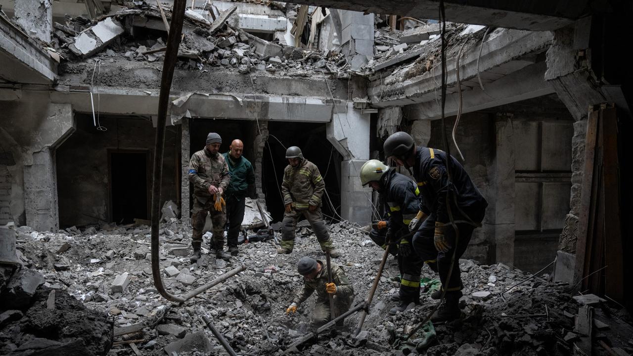 A soldier searches for bodies in the rubble of a building hit by a Russian missile last week. Picture: Getty Images