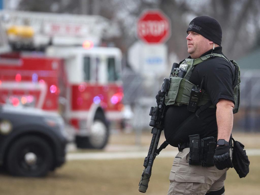 A police officer stands guard outside the Perry Middle School (Photo by SCOTT OLSON / GETTY IMAGES NORTH AMERICA / Getty Images via AFP)