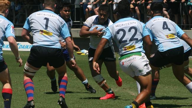 Young rugby player Unga Latu playing in his red boots on the weekend.