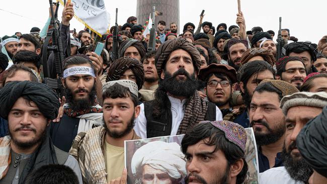 A Taliban fighter holds a poster of late Afghan leader of the Haqqani network Jalaluddin Haqqani while chanting victory slogans at the Ahmad Shah Massoud Square near the US embassy in Kabul on August 15.