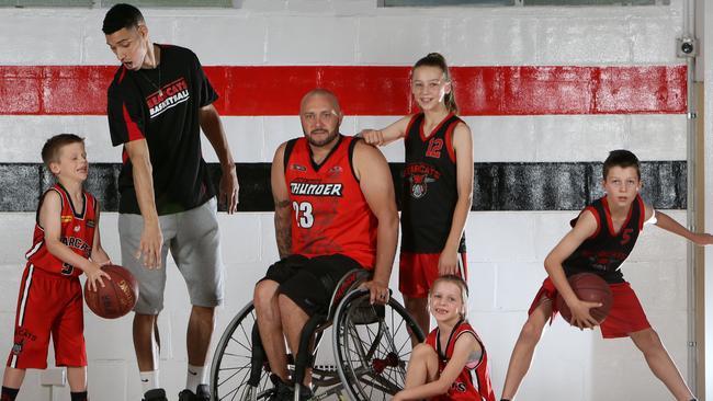 West Adelaide’s Joshua Grieger, 12, with Bearcats import Bryan Jefferson, SA wheelchair basketballer Phil Stephensm Sienna Grieger, 12, Leila Grieger 7, and Aiden Grieger, 10. Adelaide’s national wheelchair basketball team the Thunder has merged with West Adelaide. Picture: AAP/Emma Brasier