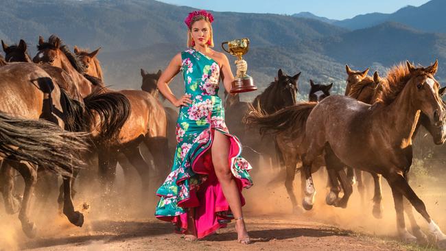 With nerves of steel model Olivia Rogers holds the Melbourne Cup standing amid a throng of 40 galloping horses from the high country. The photo was two years in the making with the horses trained for the picture and a failed attempt due to weather. Picture: Jason Edwards