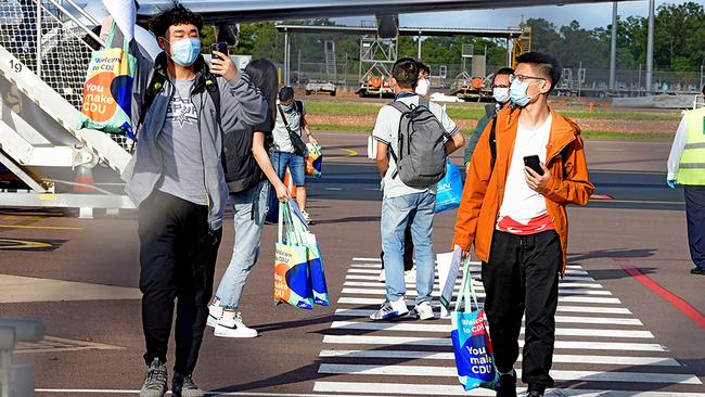 Foreign students disembark from an international flight at Darwin Airport last November. The charter flight organised by Charles Darwin University was the first time students had entered Australia since the previous March. Picture: Charles Darwin University/AFP