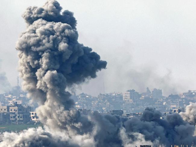 TOPSHOT - This picture taken from the Israeli side of the border with the Gaza Strip shows smoke plumes rising from explosions above destroyed buildings in the northern Gaza Strip on January 14, 2025, amid the ongoing war between Israel and Hamas. (Photo by Jack GUEZ / AFP)