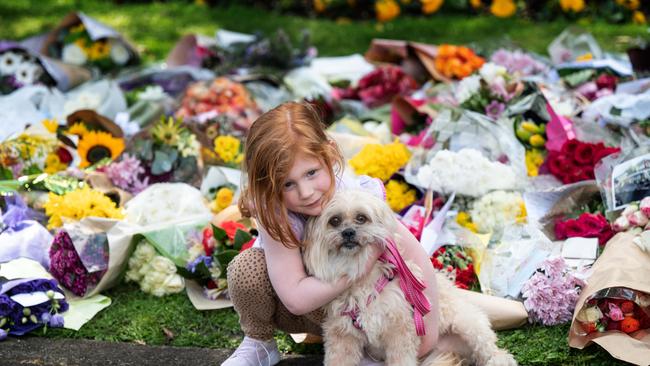 Trixie Neil, 4, with her dog Lucy. Melburnians leave flowers and condolence messages after the passing of Queen Elizabeth II. Picture: Tony Gough