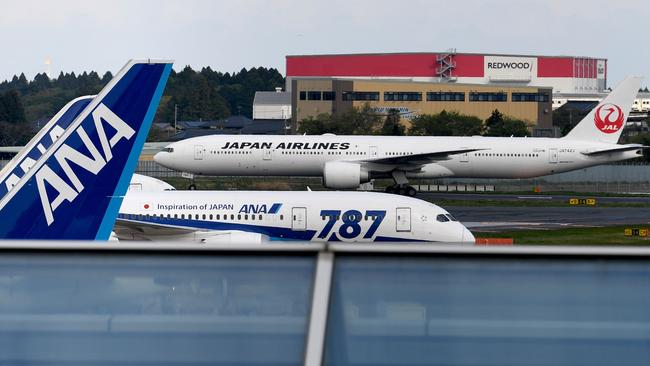 A Japan Airlines plane taxis past an All Nippon Airways plane at Narita International Airport. Picture; AFP.