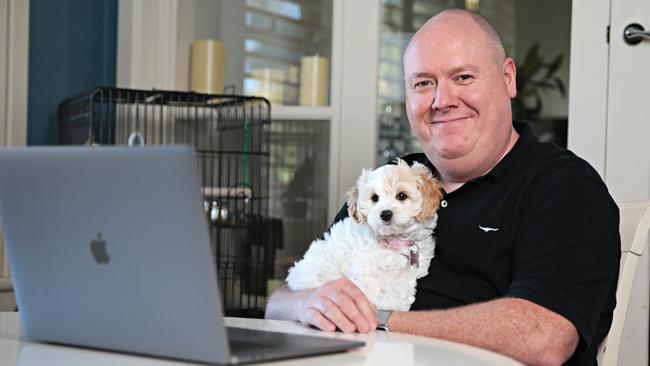 Grant Keogh with his new puppy Bella (8weeks) Cavoodle at his home office in Cheltenham on the 17th of August. PICTURE: Adam Yip