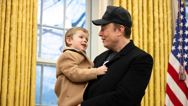 Elon Musk carries his son X in the Oval Office of the White House.