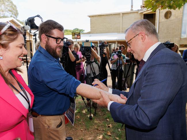 Prime Minister Anthony Albanese writes and signs Ã¢â¬ËNo Change To WA GSTÃ¢â¬â¢ on the forearm of Dylan Caporn, State Political reporter for The West Australian before signing a copy of The West Australian newspaper with the headline Ã¢â¬ËÃ¢â¬â¢Take GST VowÃ¢â¬â¢ during a press conference at Thornlie TAFE in Perth, Monday, February 19, 2024. (AAP Image/Richard Wainwright) NO ARCHIVING