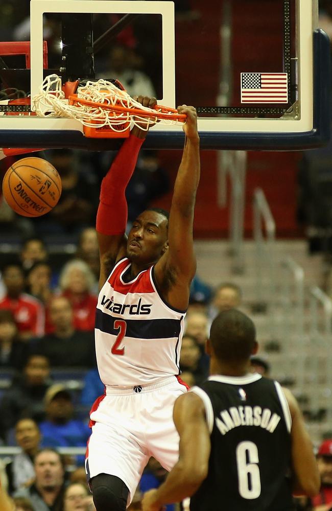 Wizards’ John Wall dunks the ball in front of Alan Anderson of the Nets.