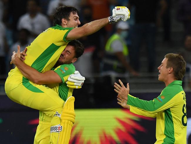 Australia's Mitchell Marsh (L) celebrates their win with teammates at the end of the ICC menâs Twenty20 World Cup final match between Australia and New Zealand at the Dubai International Cricket Stadium in Dubai on November 14, 2021. (Photo by INDRANIL MUKHERJEE / AFP)