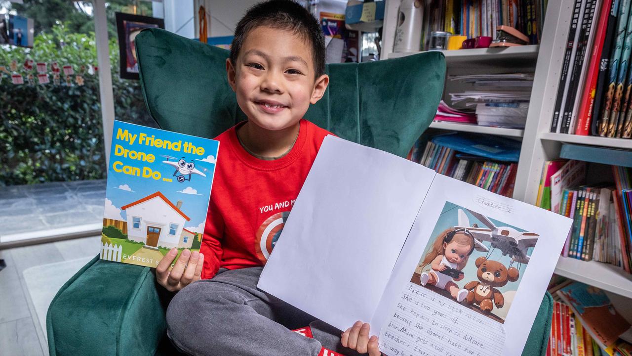 Winner of the K-2 category of the 2023 Kids News Short Story Competition, Everest Song, 7, now in Grade 2 at Serpell Primary School in Victoria, is pictured with one of his original stories at right, and his winning entry published as a book by HarperCollins, left. Picture: Jake Nowakowski