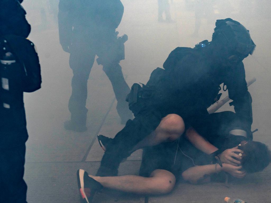 A pro-democracy protester is arrested by riot police in a cloud of tear gas during a demonstration in Hong Kong. Picture: Getty Images