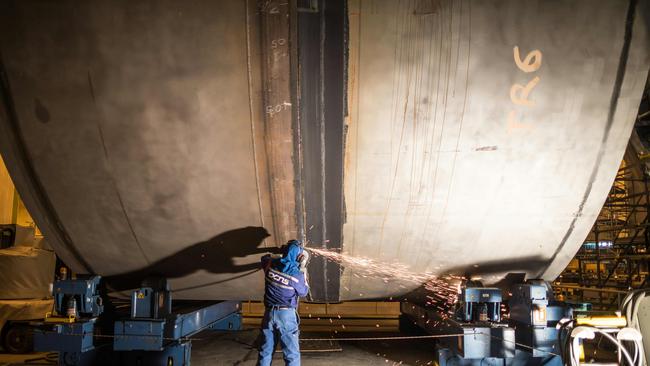 A welder working on the assembly of a Barracuda Suffren class submarine.