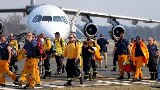 DNSW Premier Gladys Berejiklian and Deputy Premier John Barilaro arrive at Port Macquarie airport with RFS volunteers. Picture: Nathan Edwards