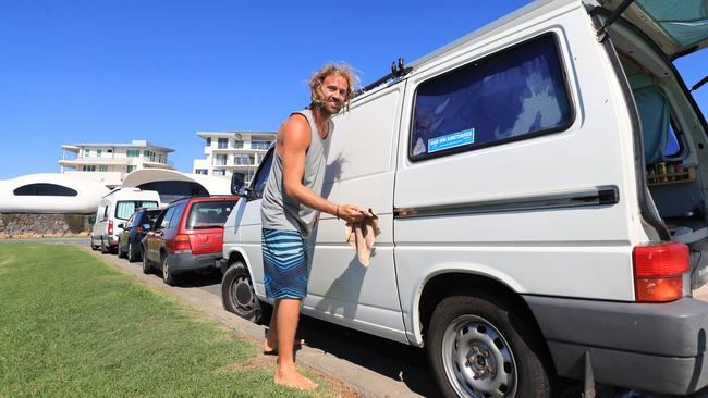 Matias Garcia finishes cleaning his van after offenders tagged it with black spray paint early this morning. Photo: Scott Powick