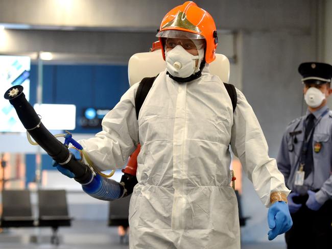 A disinfection worker of Budapest’s Liszt Ferenc Airport of arrives with a sprayer machine. Picture: Attila Kisbenedek/AFP